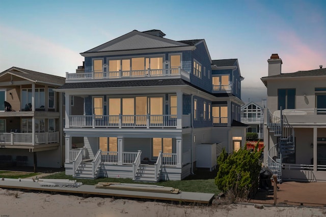 back house at dusk with a balcony