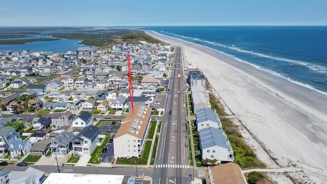 bird's eye view featuring a water view and a beach view