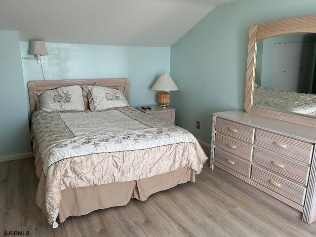 bedroom with light hardwood / wood-style flooring and vaulted ceiling