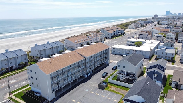 birds eye view of property featuring a water view and a beach view