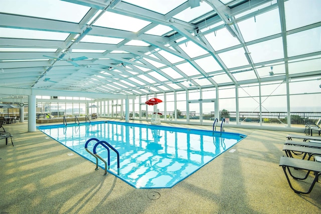 pool with a patio area and glass enclosure