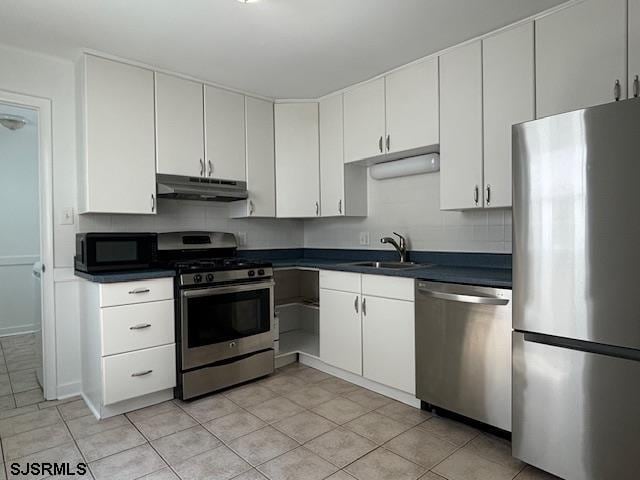 kitchen with white cabinetry, backsplash, appliances with stainless steel finishes, and light tile patterned floors