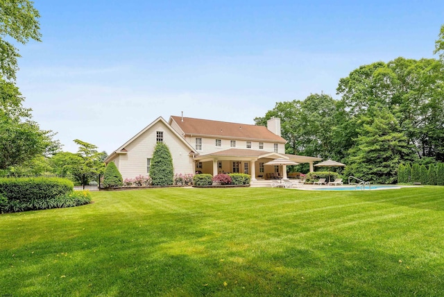 rear view of house featuring a yard and a patio area