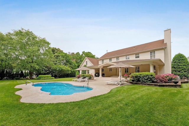 view of pool with a patio area and a yard