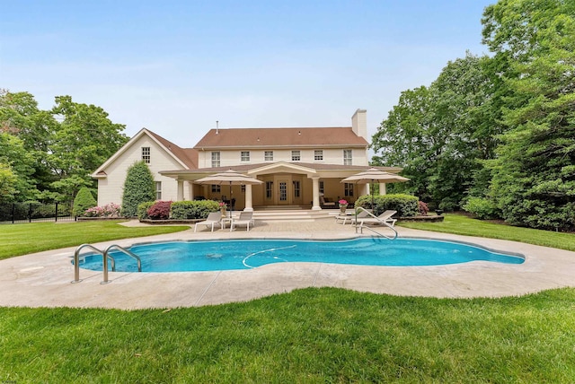 view of swimming pool with a patio area and a yard