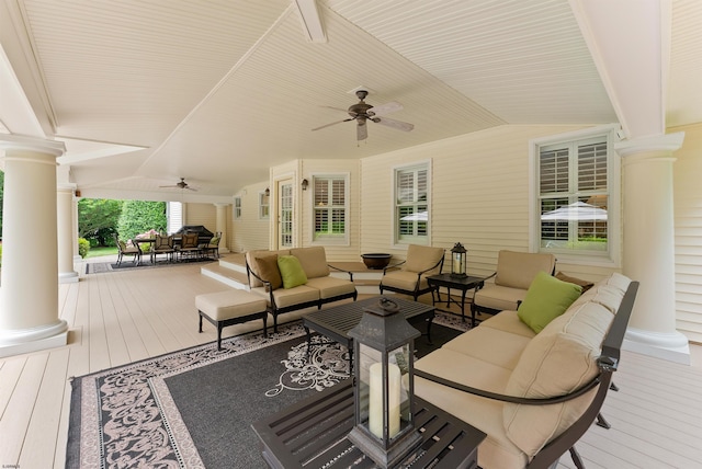 wooden terrace with an outdoor living space and ceiling fan