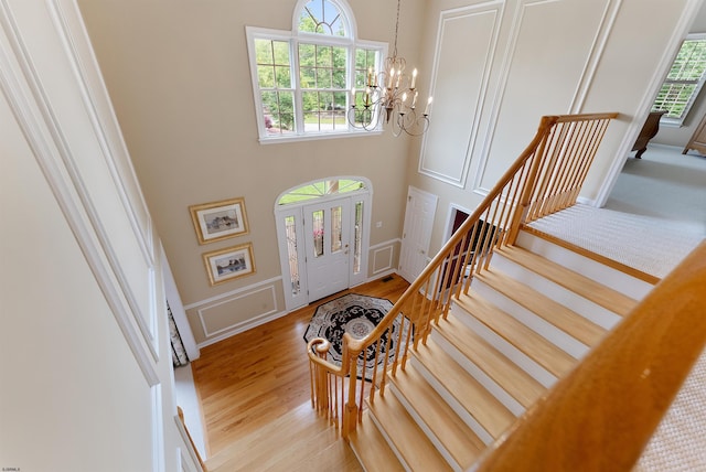 foyer entrance with a chandelier, a high ceiling, and light hardwood / wood-style floors