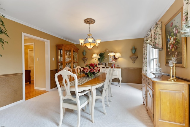 dining area featuring light carpet, crown molding, and a notable chandelier