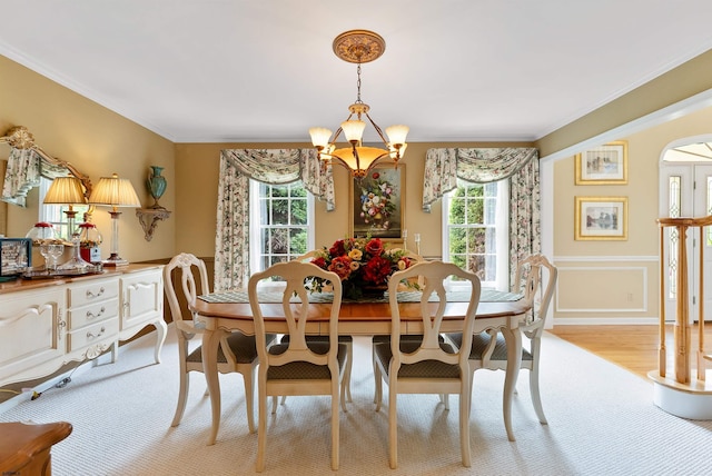 dining space with light hardwood / wood-style floors, an inviting chandelier, and a wealth of natural light