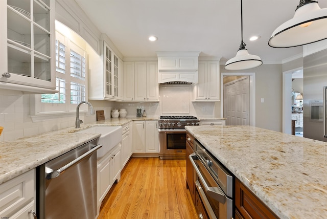 kitchen with pendant lighting, sink, white cabinetry, and stainless steel appliances