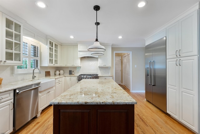 kitchen featuring pendant lighting, a center island, white cabinets, and appliances with stainless steel finishes