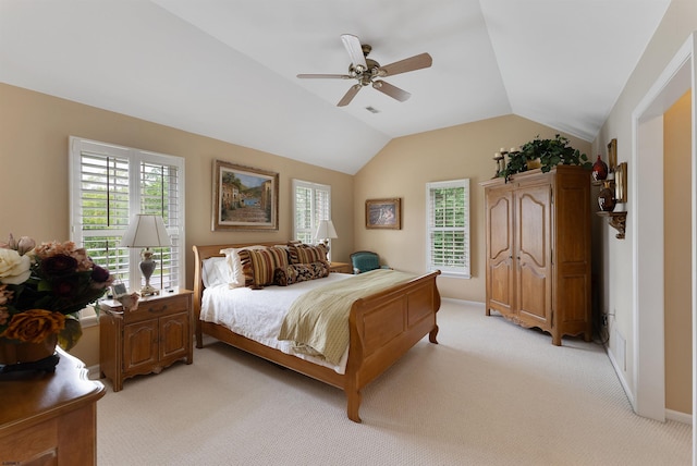 carpeted bedroom with ceiling fan and vaulted ceiling