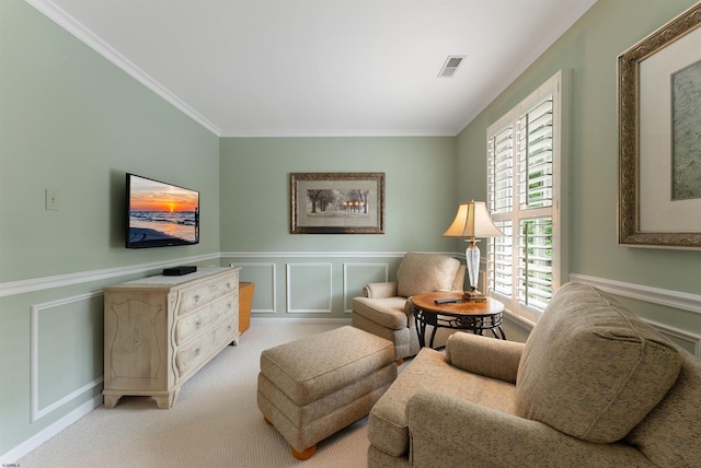 sitting room with ornamental molding and light carpet