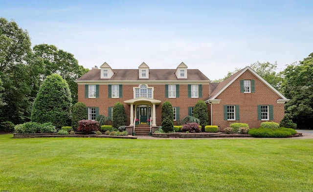 colonial inspired home with a front lawn