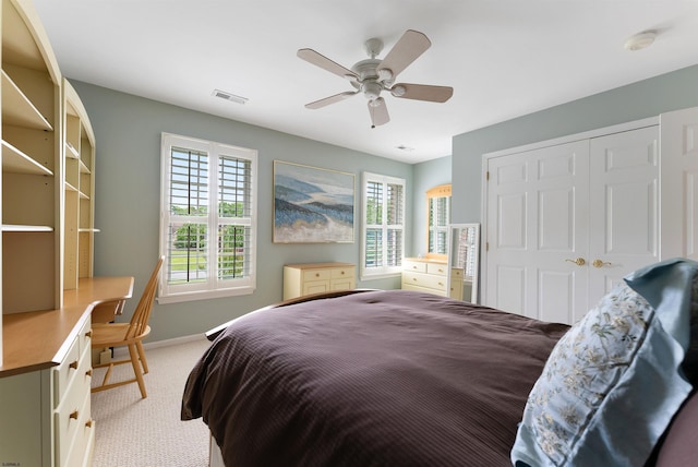 carpeted bedroom featuring ceiling fan and a closet