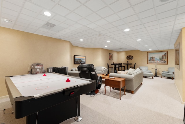 game room with a paneled ceiling and light colored carpet