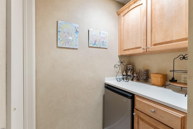 kitchen featuring dishwasher, light brown cabinetry, and refrigerator