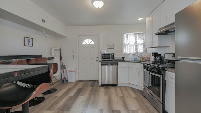 kitchen featuring stainless steel appliances, white cabinetry, light hardwood / wood-style floors, and sink