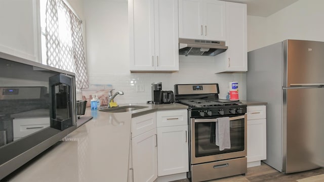 kitchen with white cabinets, sink, stainless steel appliances, and hardwood / wood-style floors