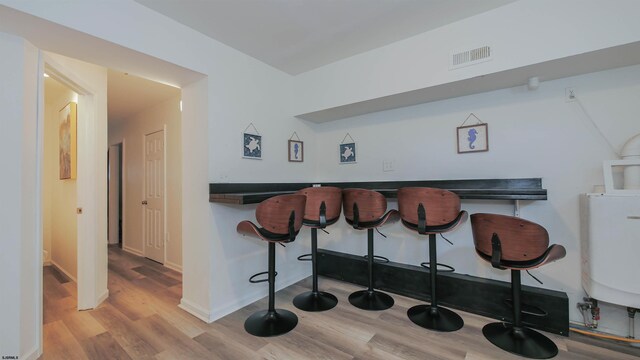 bar featuring light hardwood / wood-style flooring