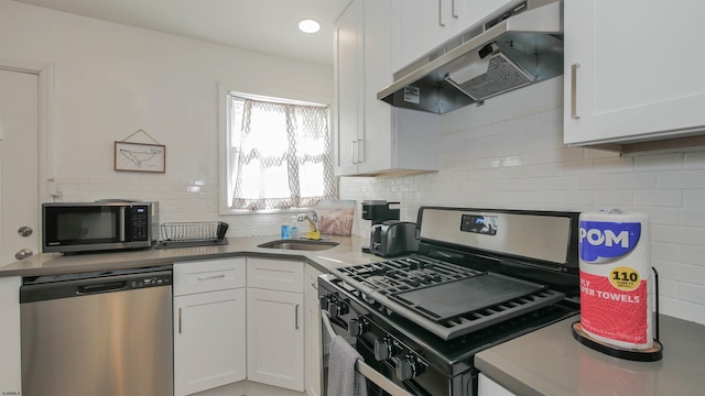 kitchen featuring white cabinets, appliances with stainless steel finishes, decorative backsplash, and sink