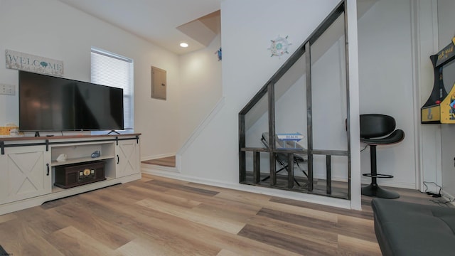 living room with light wood-type flooring and electric panel