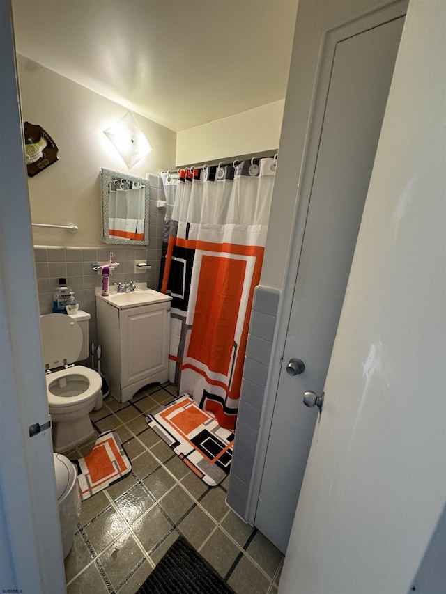 bathroom with vanity, toilet, tile walls, and curtained shower