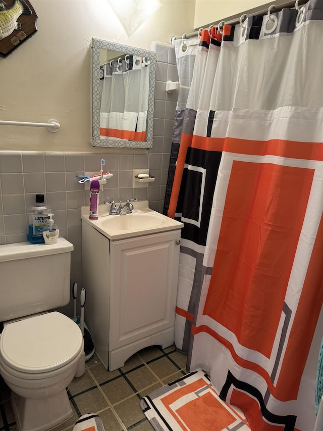 bathroom featuring vanity, a shower with curtain, tile patterned flooring, toilet, and tile walls