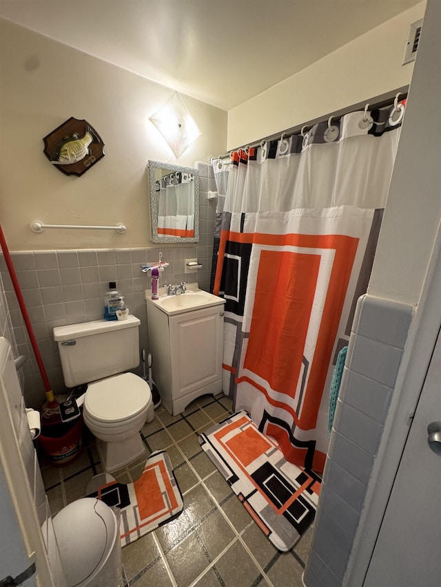 bathroom with a shower with shower curtain, vanity, toilet, and tile walls