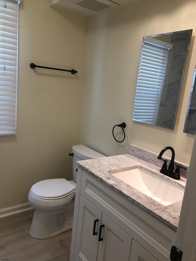 bathroom featuring hardwood / wood-style flooring, vanity, and toilet