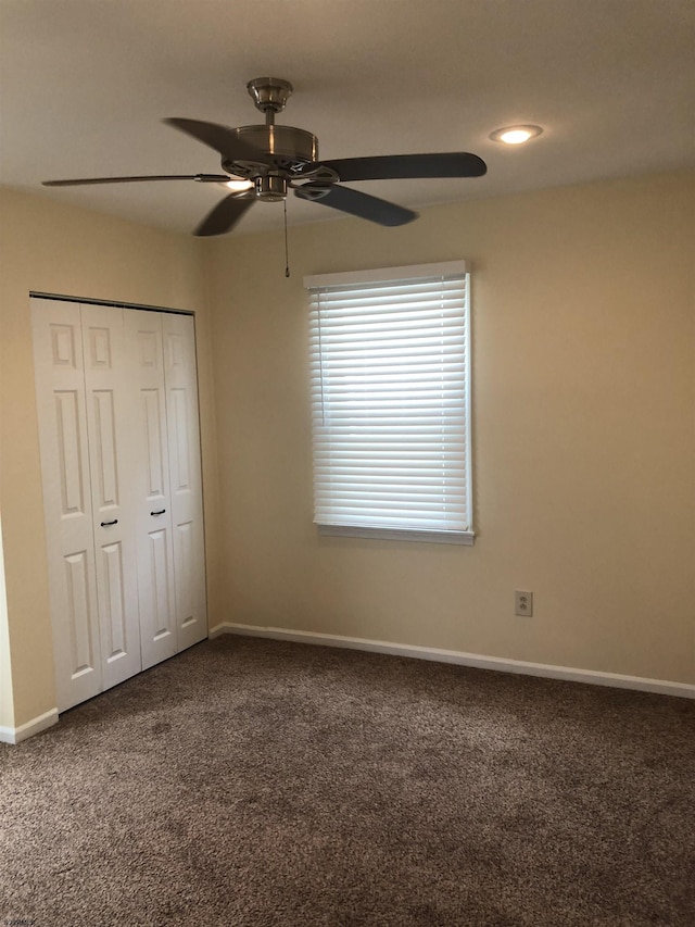 unfurnished bedroom with carpet, a closet, and ceiling fan