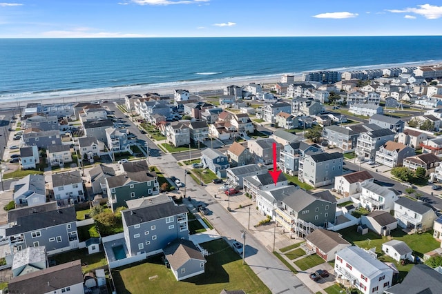 drone / aerial view featuring a water view and a view of the beach