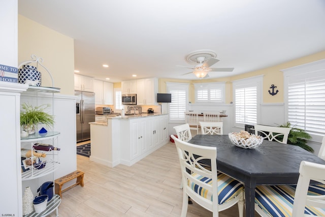 dining area with ceiling fan and light wood-type flooring