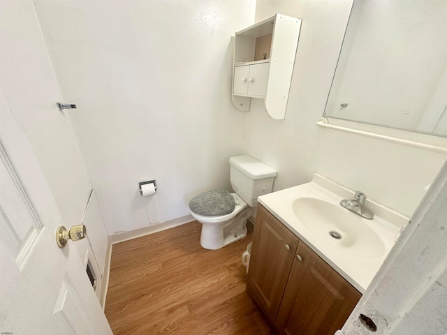 bathroom with hardwood / wood-style floors, toilet, and vanity