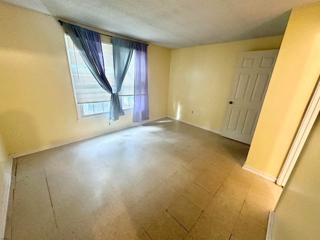 tiled spare room with a textured ceiling