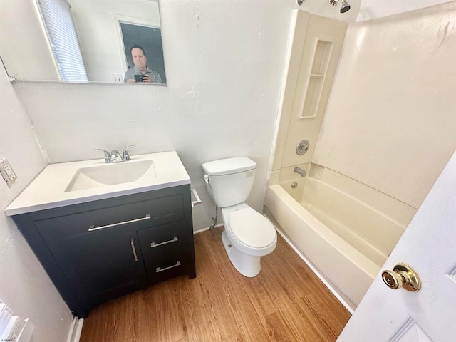 full bathroom with wood-type flooring, vanity with extensive cabinet space, shower / tub combination, and toilet