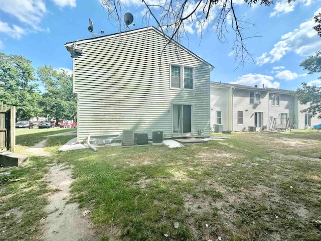 rear view of house with a yard and central air condition unit