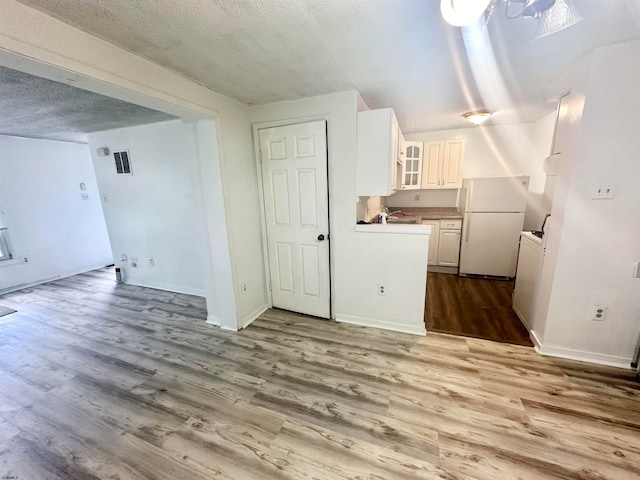 interior space with a textured ceiling and wood-type flooring