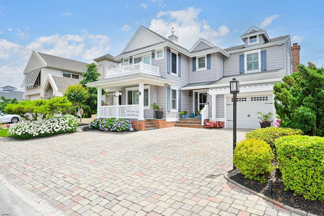 view of front of property with covered porch, a garage, and a balcony