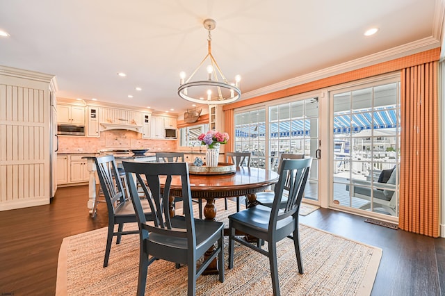 dining space with crown molding, dark hardwood / wood-style flooring, a chandelier, and sink