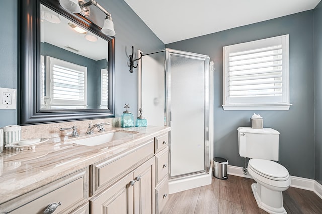 bathroom featuring hardwood / wood-style flooring, toilet, vanity, and walk in shower