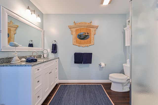 bathroom featuring vanity, hardwood / wood-style flooring, and toilet