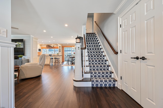 stairway with hardwood / wood-style floors and ornamental molding