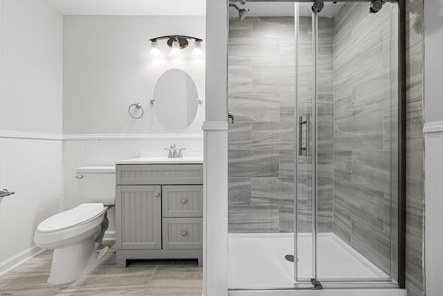 bathroom featuring vanity, toilet, and a shower with shower door