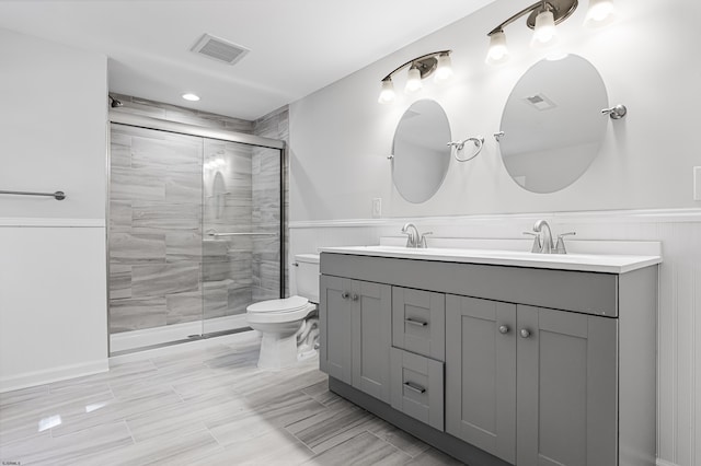 bathroom featuring vanity, an enclosed shower, and toilet