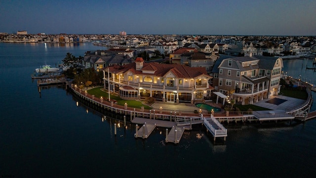 aerial view at dusk featuring a water view