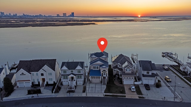 aerial view at dusk featuring a water view