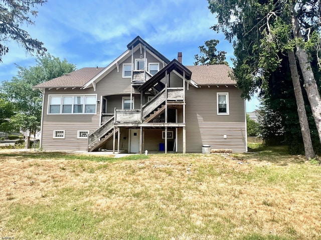 back of house with a deck and a lawn