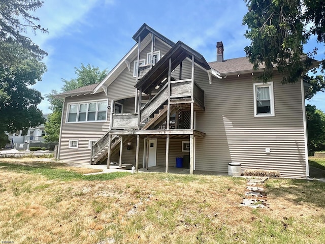 rear view of property featuring a lawn