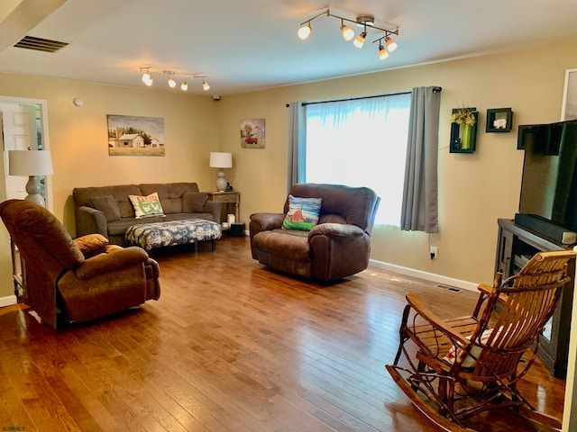 living room with hardwood / wood-style flooring and track lighting